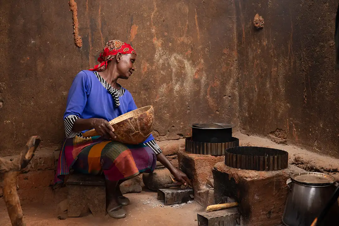 A Kenyan woman uses a improved cookstove in her home