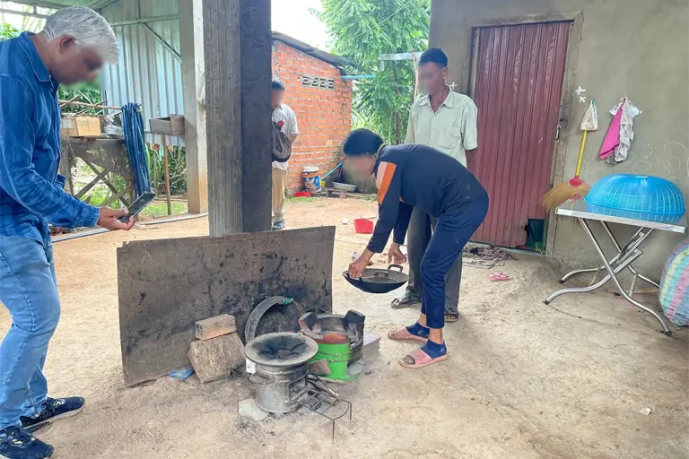 A group of Cambodian citizens utilize their improved cookstove for the first time